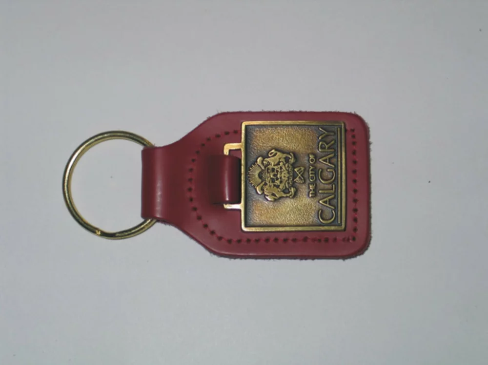 Étiquette de clé rectangulaire en cuir pleine fleur avec porte-clés en métal et médaillon.